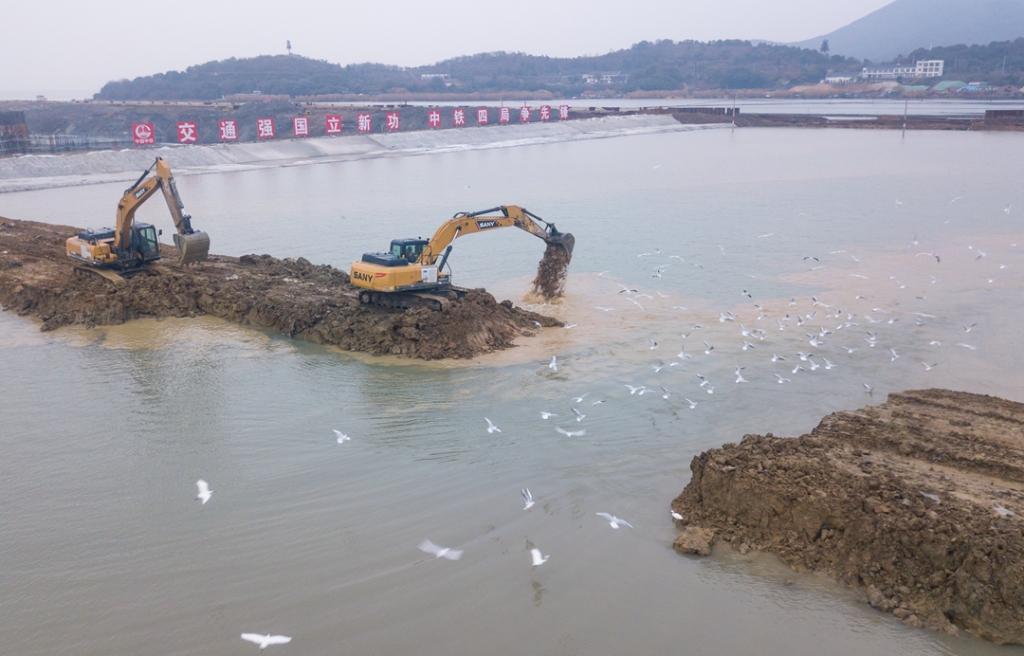 2019年12月23日，鳥群從陸島轉(zhuǎn)換圍堰回水施工現(xiàn)場飛過。